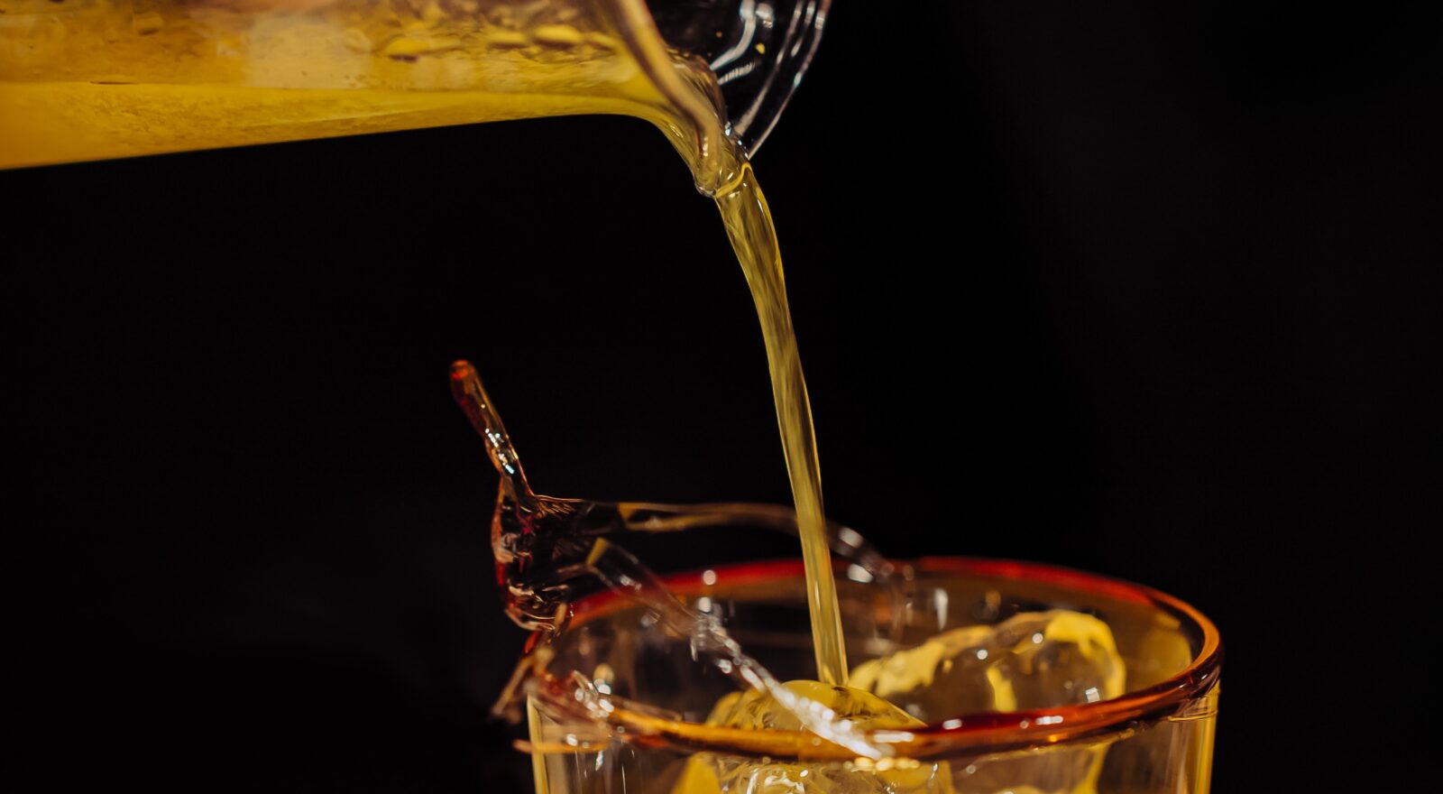 Precisely measuring and pouring a spirit sample, reflecting the proof and volume tracking distilleries must manage