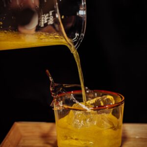 Precisely measuring and pouring a spirit sample, reflecting the proof and volume tracking distilleries must manage