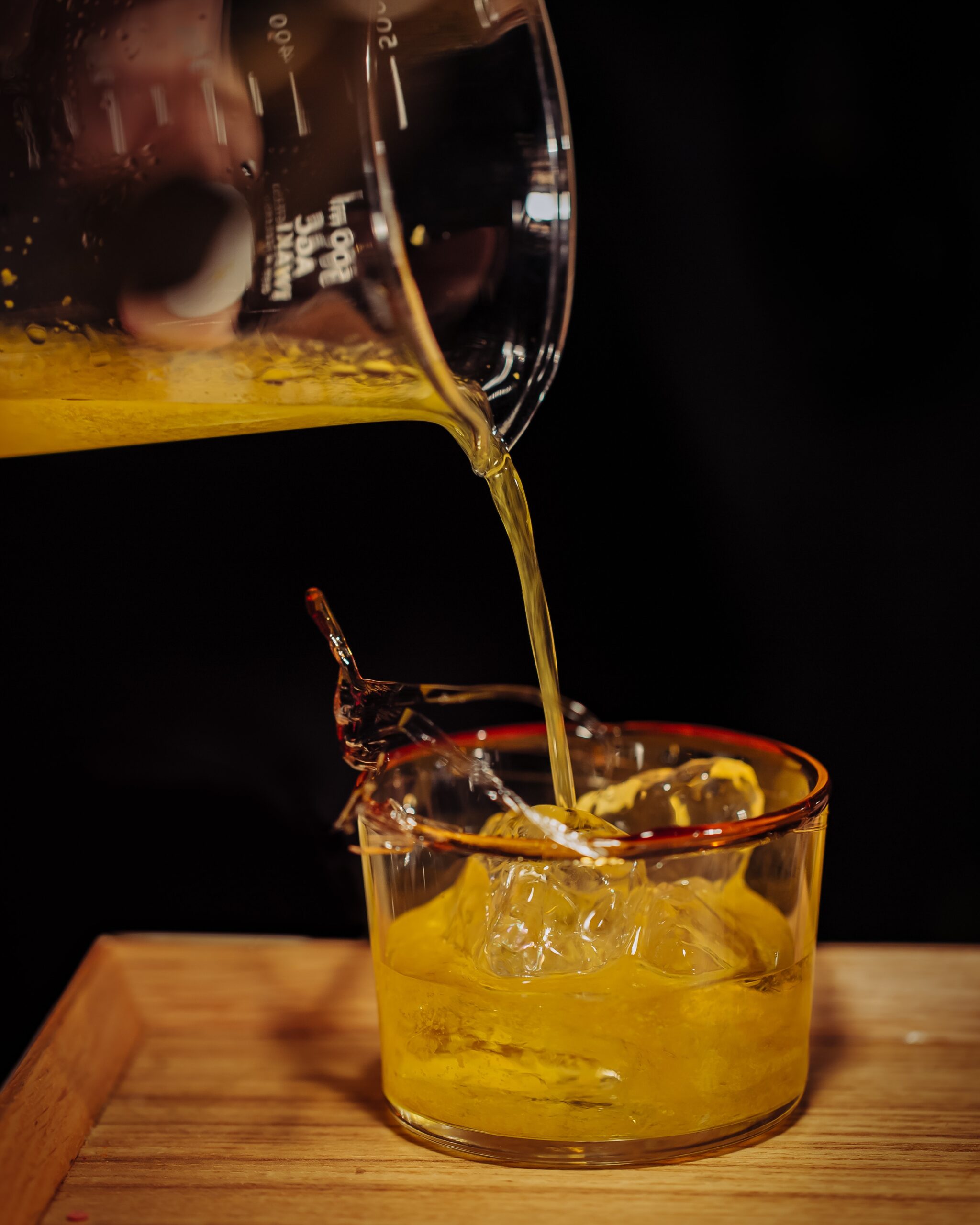 Precisely measuring and pouring a spirit sample, reflecting the proof and volume tracking distilleries must manage